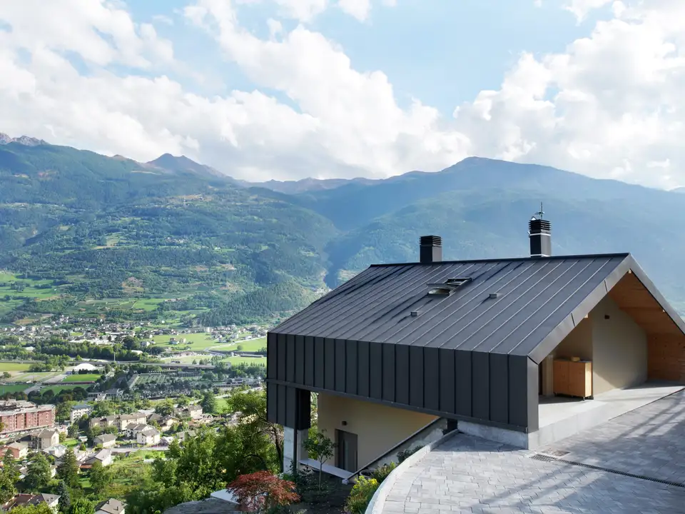 Casa moderna in montagna con tetto in metallo e finestra per tetti VELUX