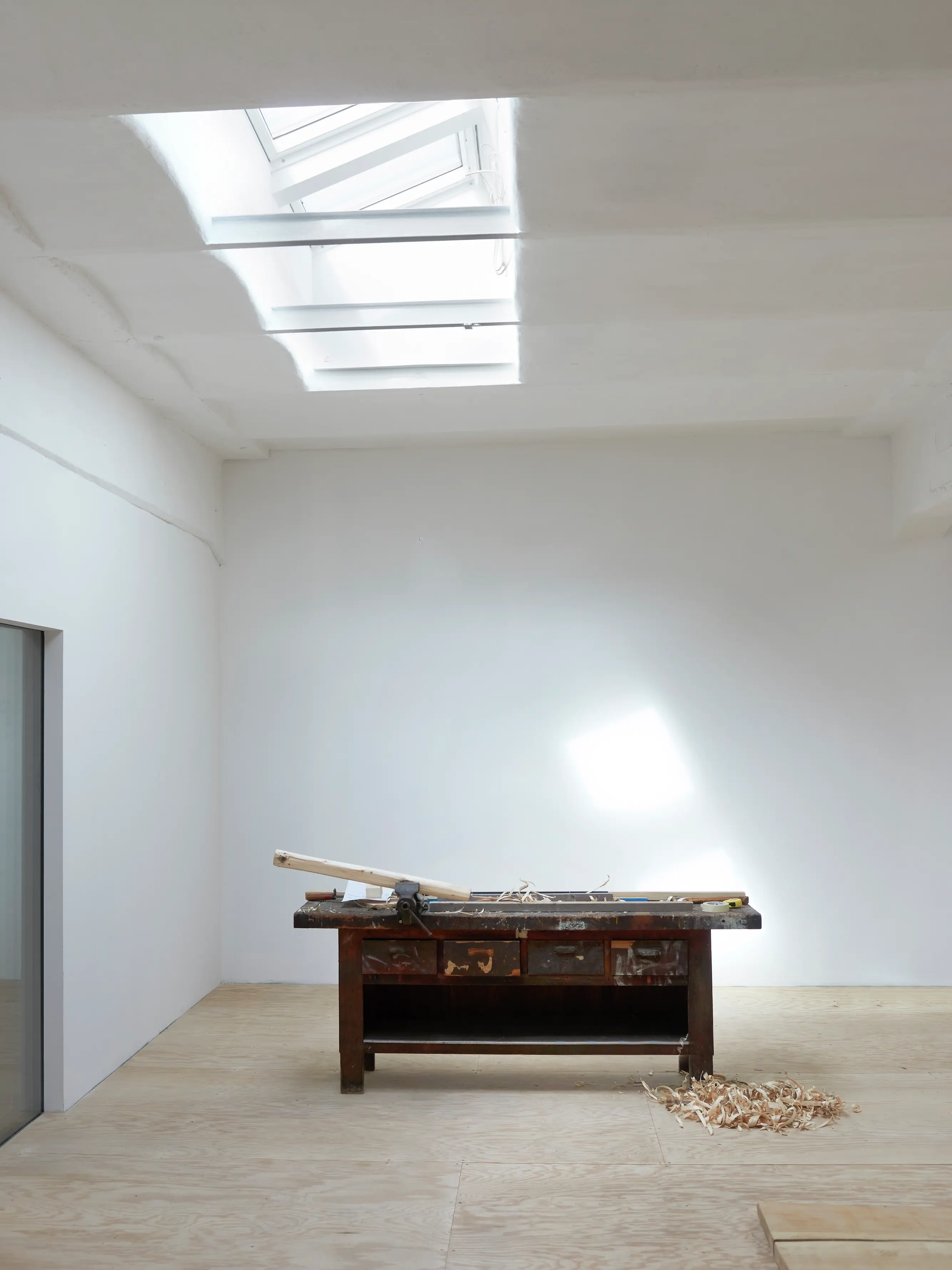 Officina con finestre per tetti VELUX che forniscono luce naturale sopra un banco da lavoro.