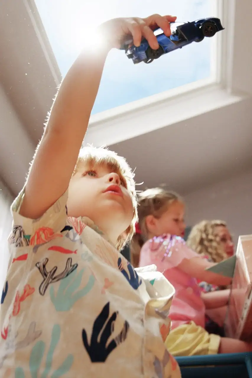 Enfants jouant sous une fenêtre de toit VELUX laissant entrer la lumière naturelle