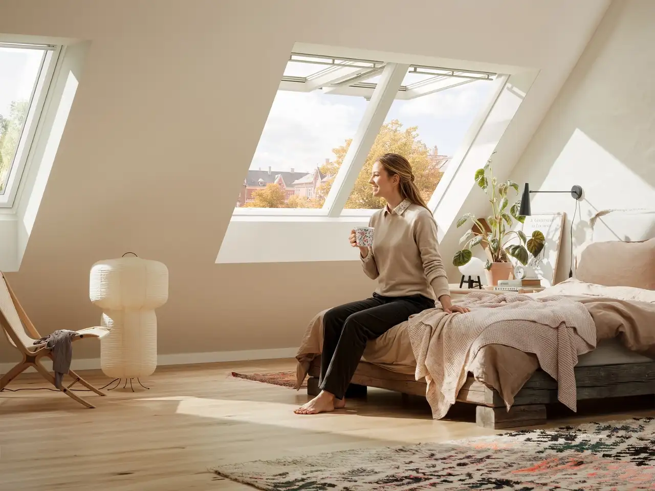 Camera da letto in mansarda con tre finestre per tetti VELUX, due aperte per ventilare.