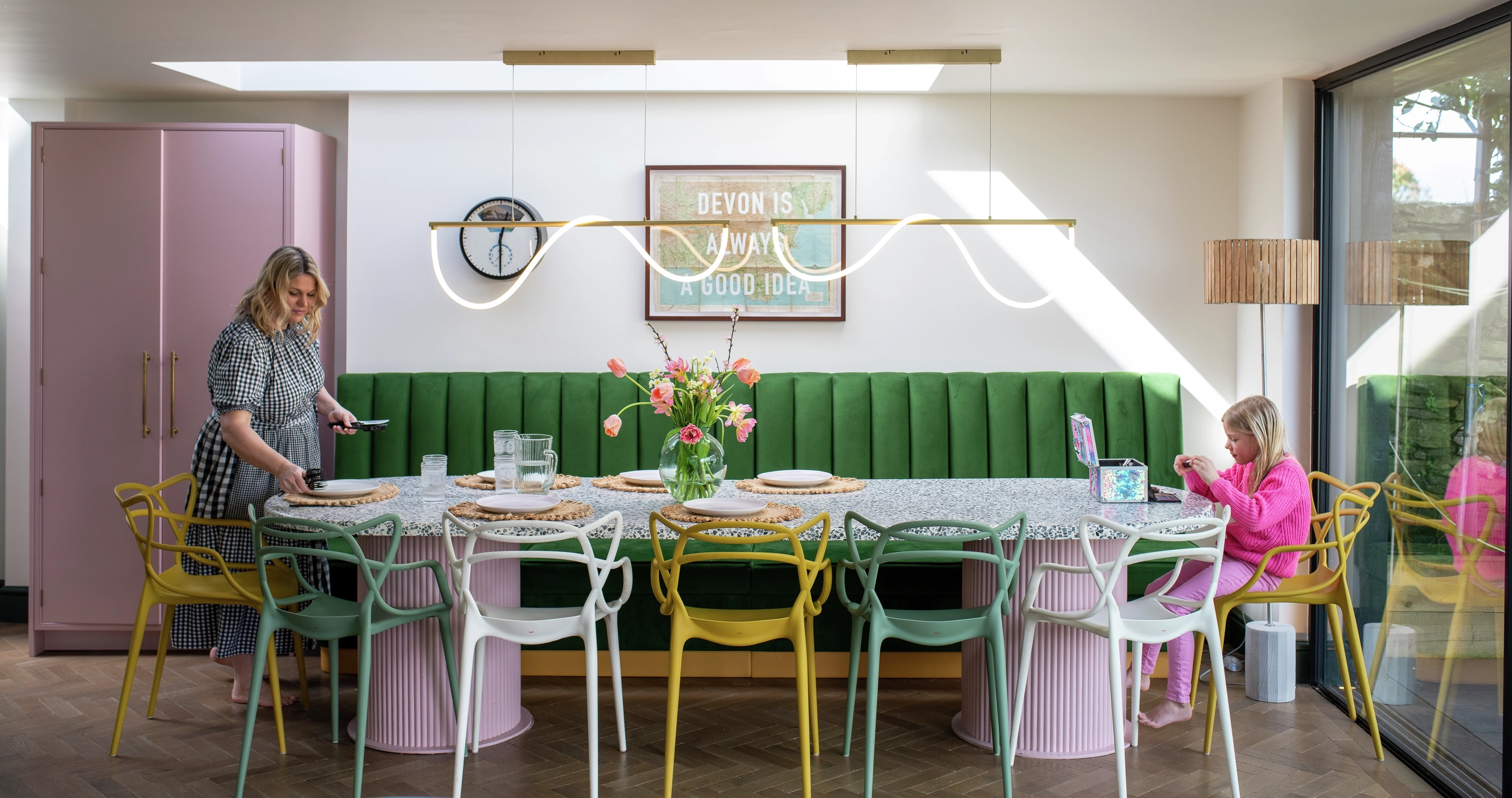 Essbereich im Danish-Pastel-Stil mit bunten Stühlen in Pastellfarben, grüner Polsterbank, rosa Schrank und modernem Esstisch | VELUX Magazin