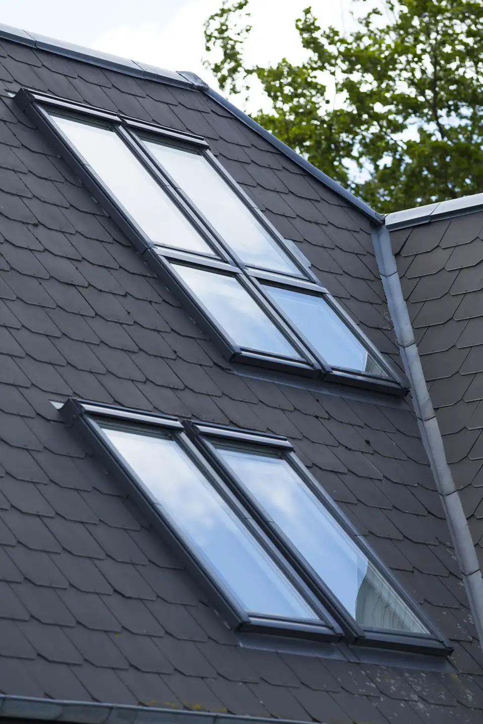 toit à forte pente avec fenêtres de toit VELUX et tuiles en ardoise