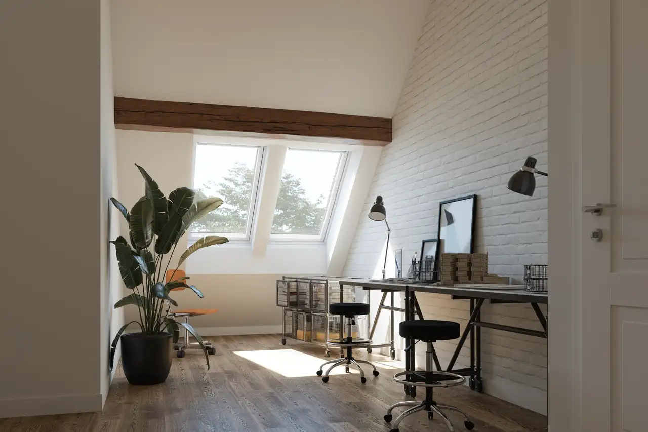 Bureau mansardé avec mur en briques blanches, double espace de travail et lumière naturelle par fenêtres de toit 