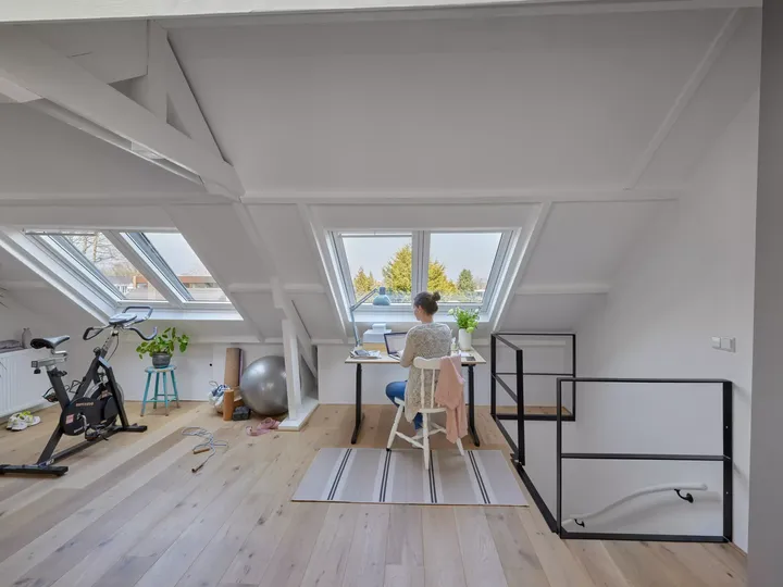 Arbeitszimmer mit Dachschräge im ausgebauten Spitzboden mit weißen Wänden, Holzboden und Dachfenstern | VELUX Magazin