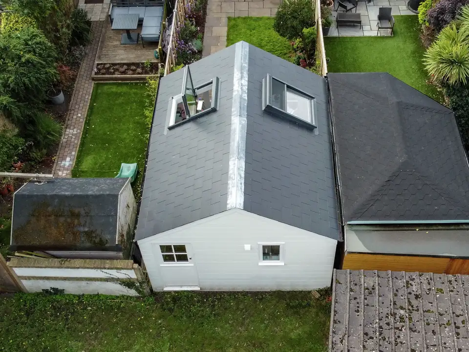 Aerial view of garden with modern extension and open VELUX roof window.