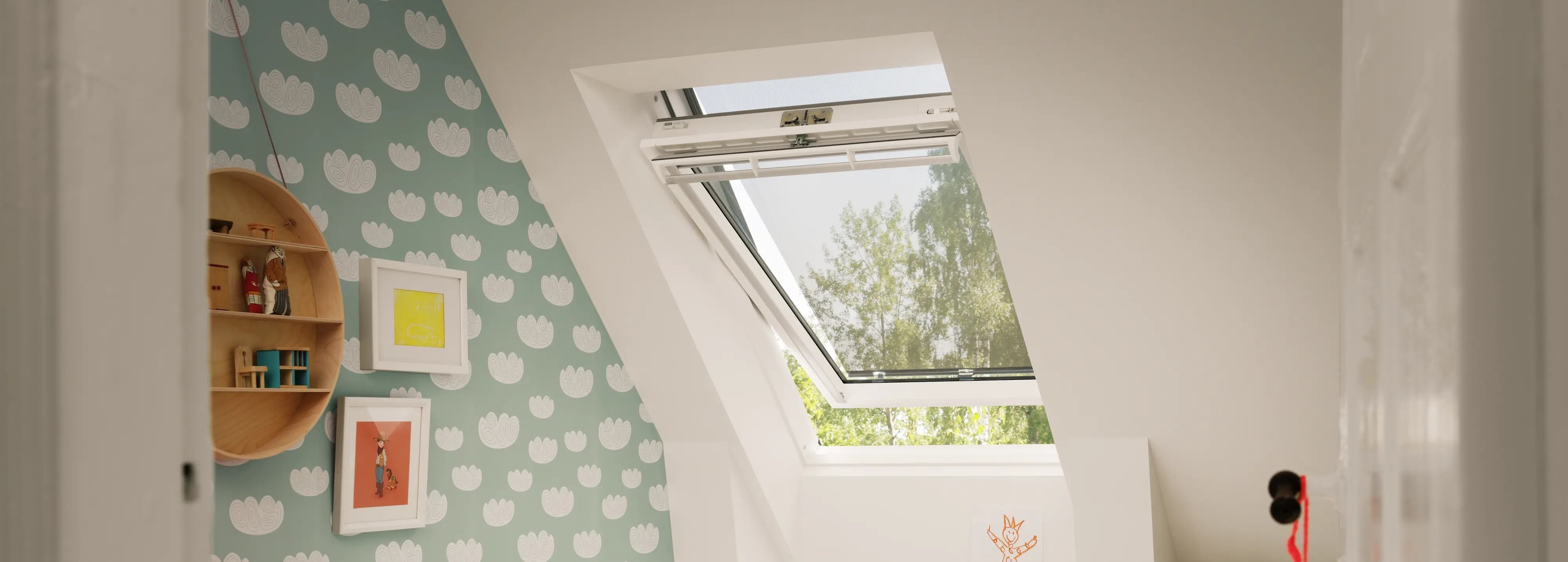 Attic kids room with sloped ceiling and open VELUX roof window, colorful decor.