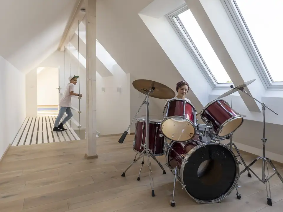 Espace musique sous combles avec batterie installée près de deux grandes fenêtres de toit VELUX 