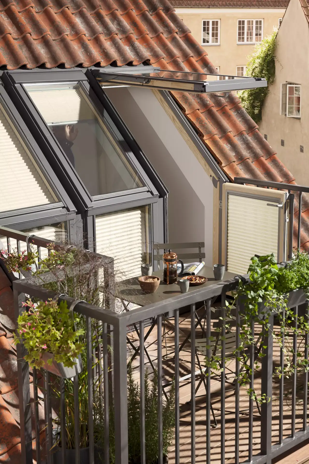 Kleine Dachterrasse mit Holzboden, Pflanzen und Balkonmobiliar | VELUX Magazin