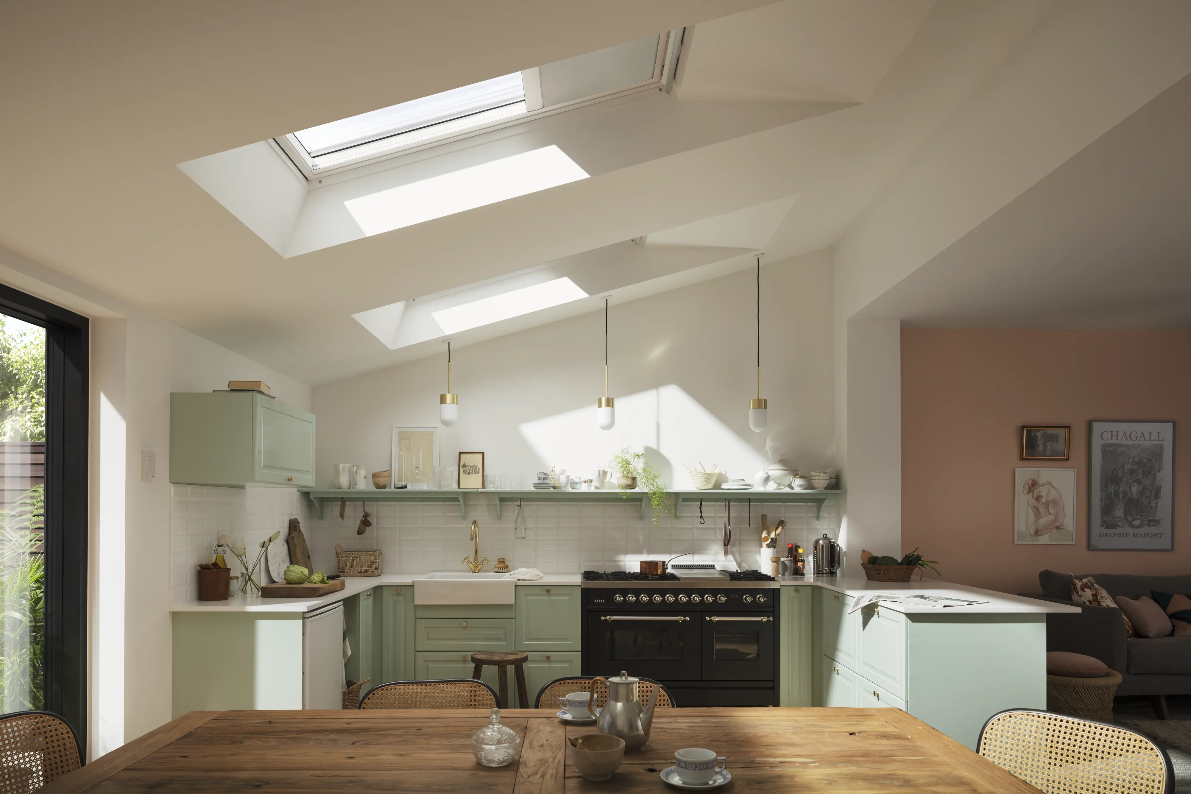 Modern kitchen with sloped ceiling and VELUX roof windows, bright and airy.