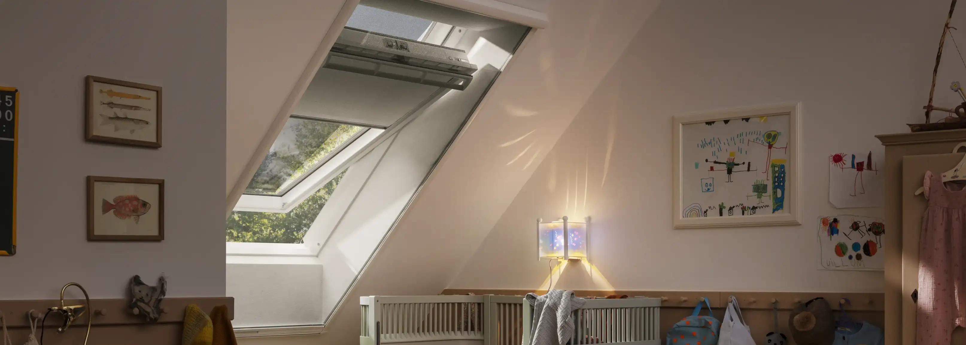 Attic kids room with sloped ceiling and VELUX roof window, filled with light.