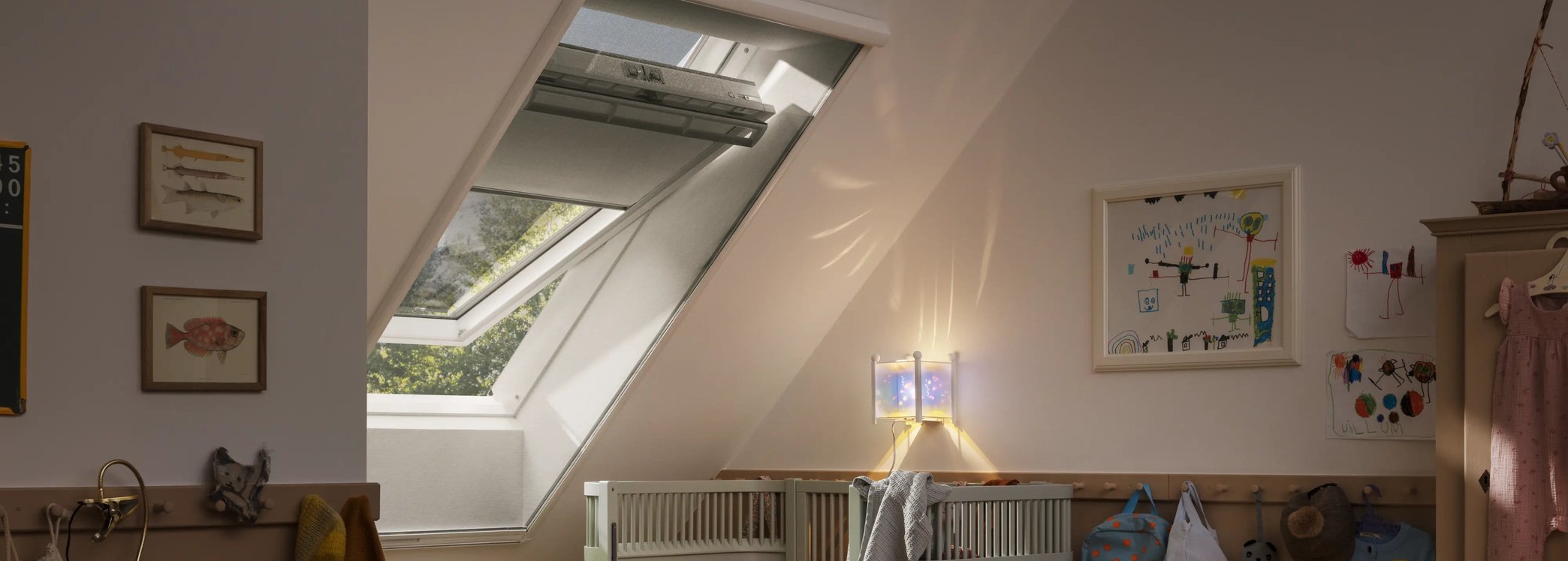 Attic kids room with sloped ceiling and VELUX roof window, filled with light.