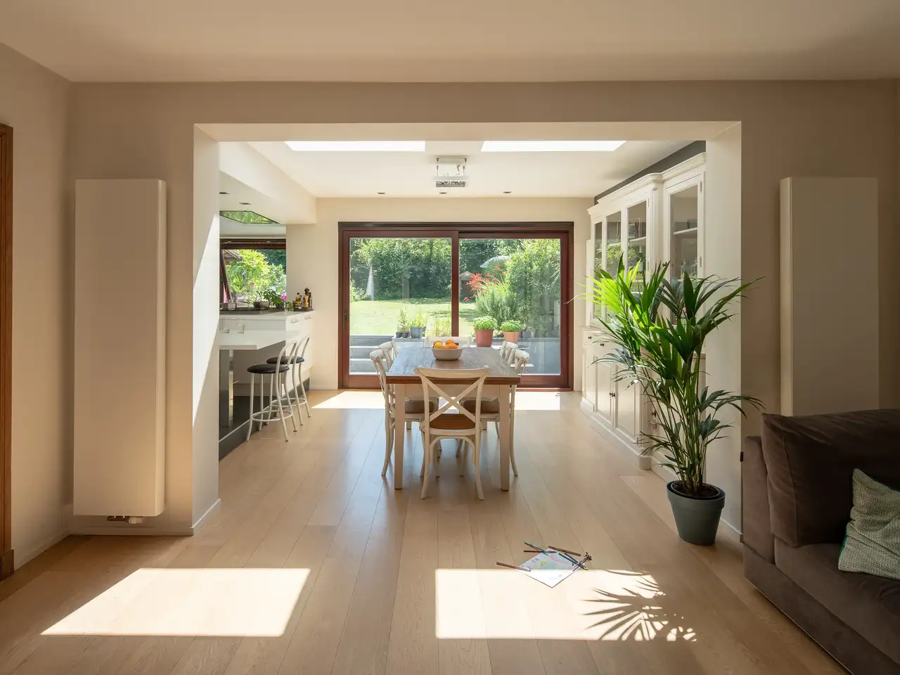 Sala da pranzo con grande tavolo, finestre per tetti piani VELUX e vista sul giardino. 