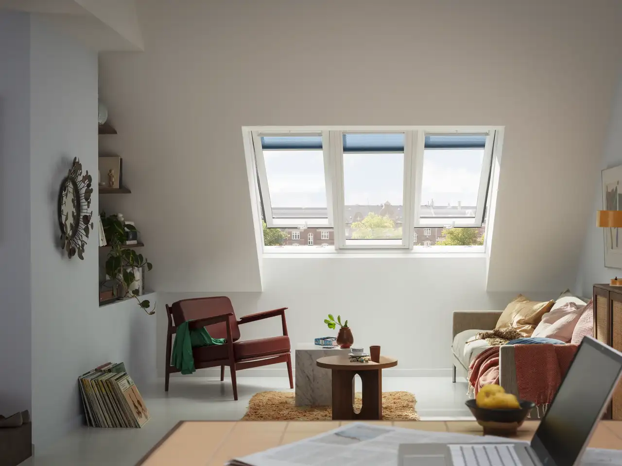 Salon moderne avec touches rétro et stores intérieurs VELUX bleus.