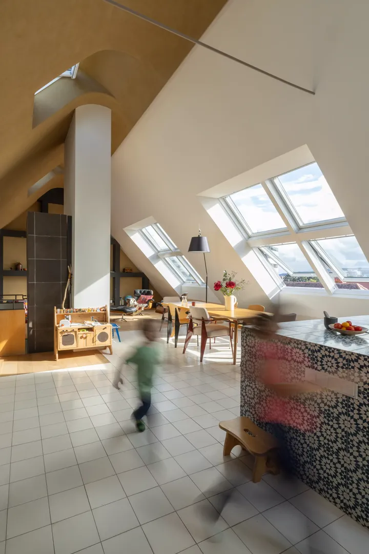 Moderne Dachbodenküche mit VELUX Dachflächenfenster und einem sich bewegenden Kind.