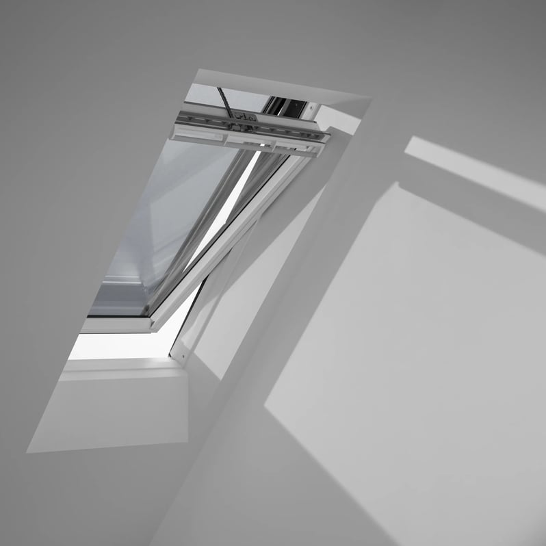 Open VELUX roof window in a bright attic room with sloped ceiling.