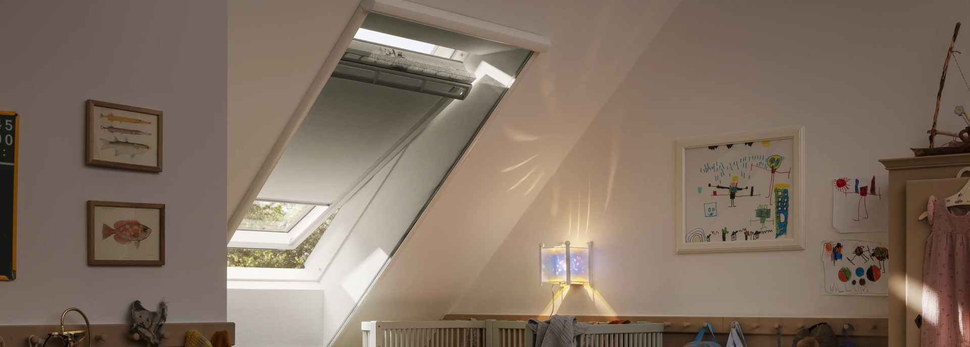 Attic kids room with sloped ceiling and VELUX roof window, playful decor.