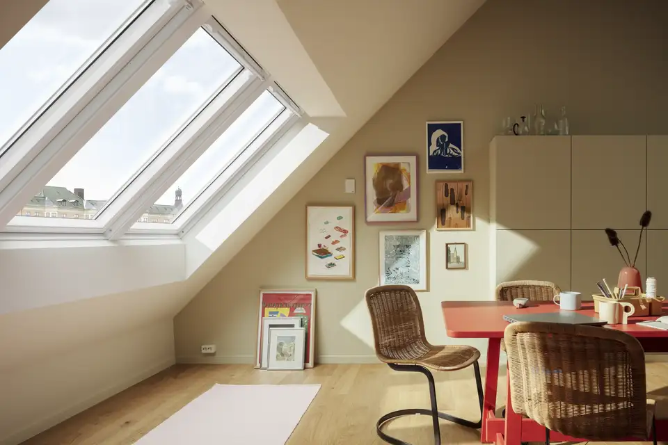 Salon mansardé, éclairé par trois fenêtres de toit : le plafond est blanc, le mur vertical brun clair.