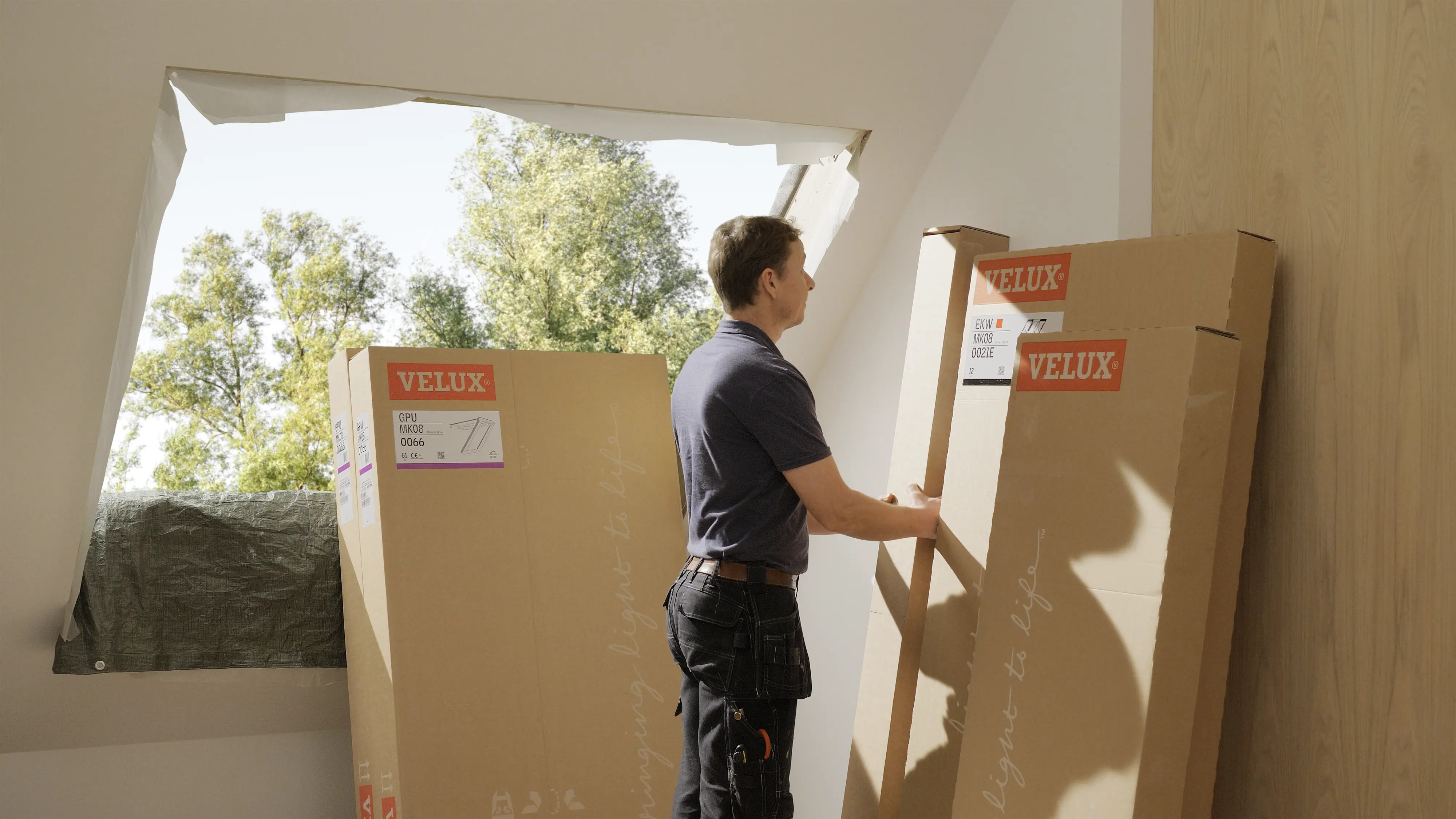 Instalator otwierający opakowanie okna dachowego