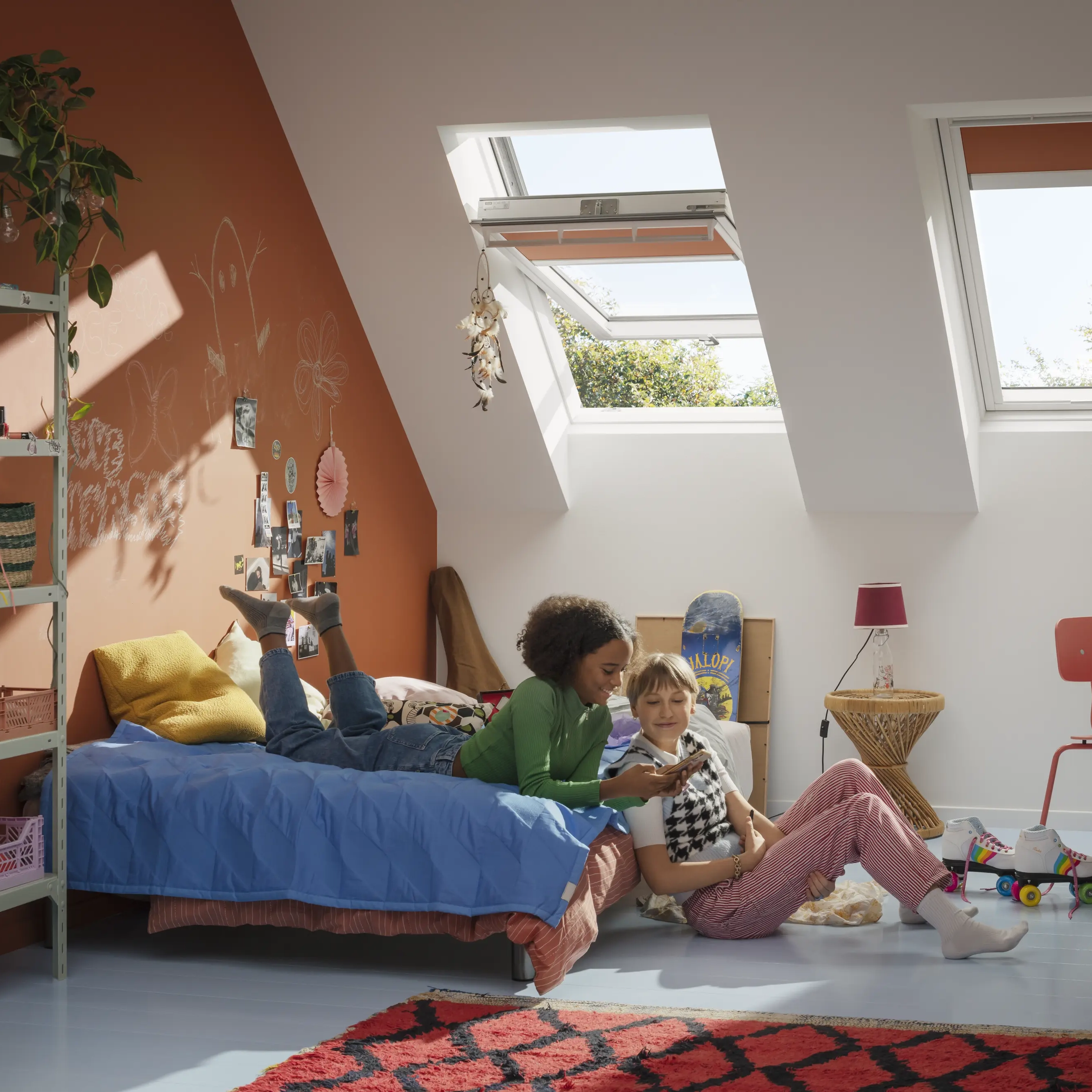 Teenage attic room with sloped ceiling and open VELUX roof windows.