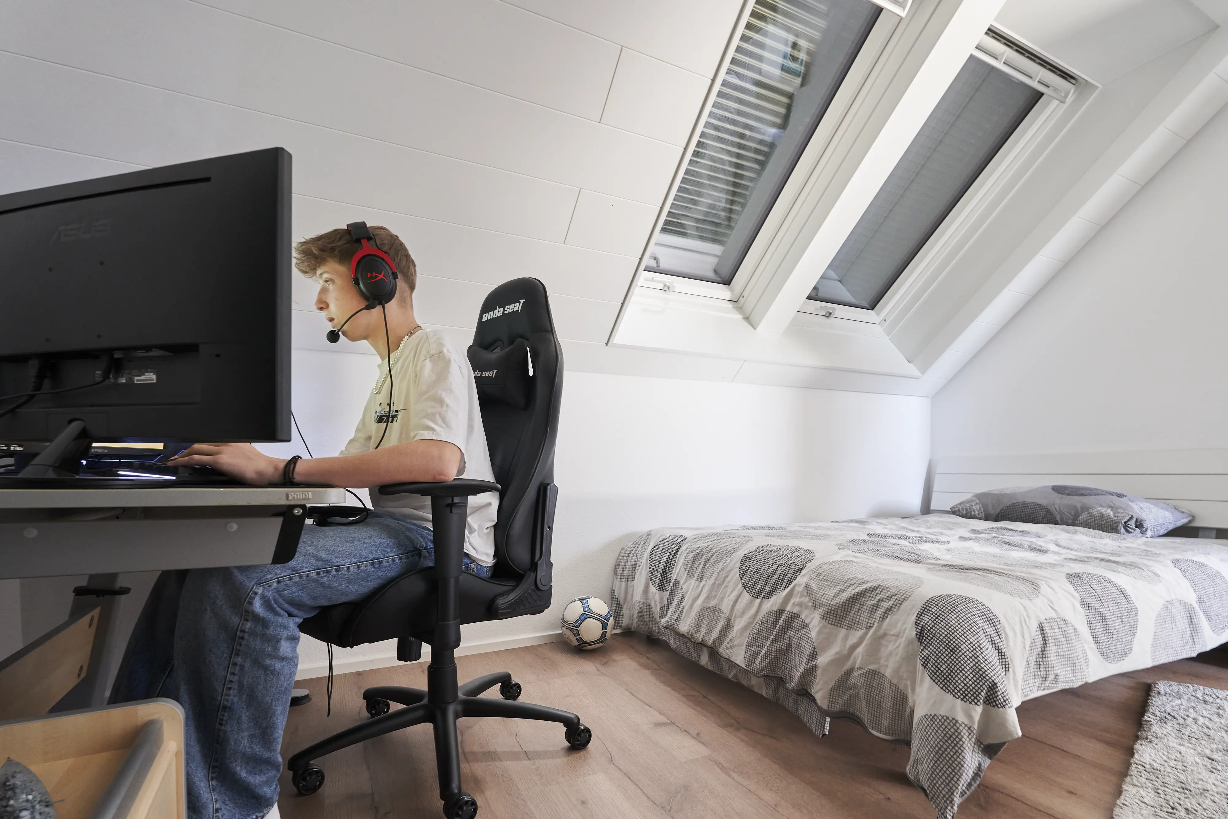 Aydınlık bir odada, çatı penceresinin altındaki masada oyun oynayan çocuk. | VELUX