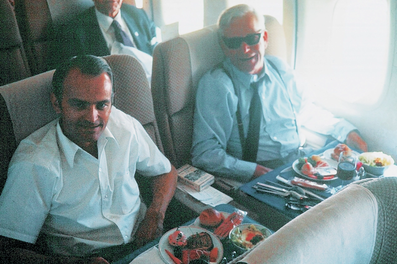 Luxuriöse Business-Class-Kabine mit edlem Essensangebot im Flugzeug.
