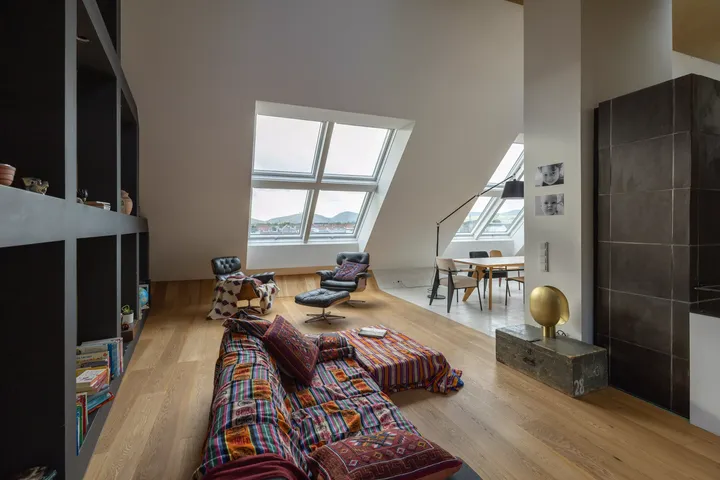Geräumiger Dachboden-Wohnbereich mit VELUX-Fenstern und eklektischer Einrichtung.