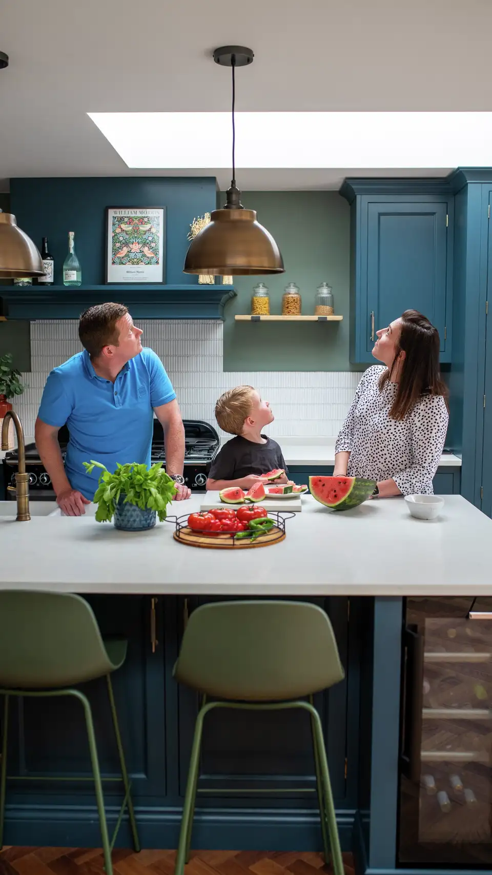 Una famiglia in una cucina moderna con una grande finestra per tetti piani VELUX. 