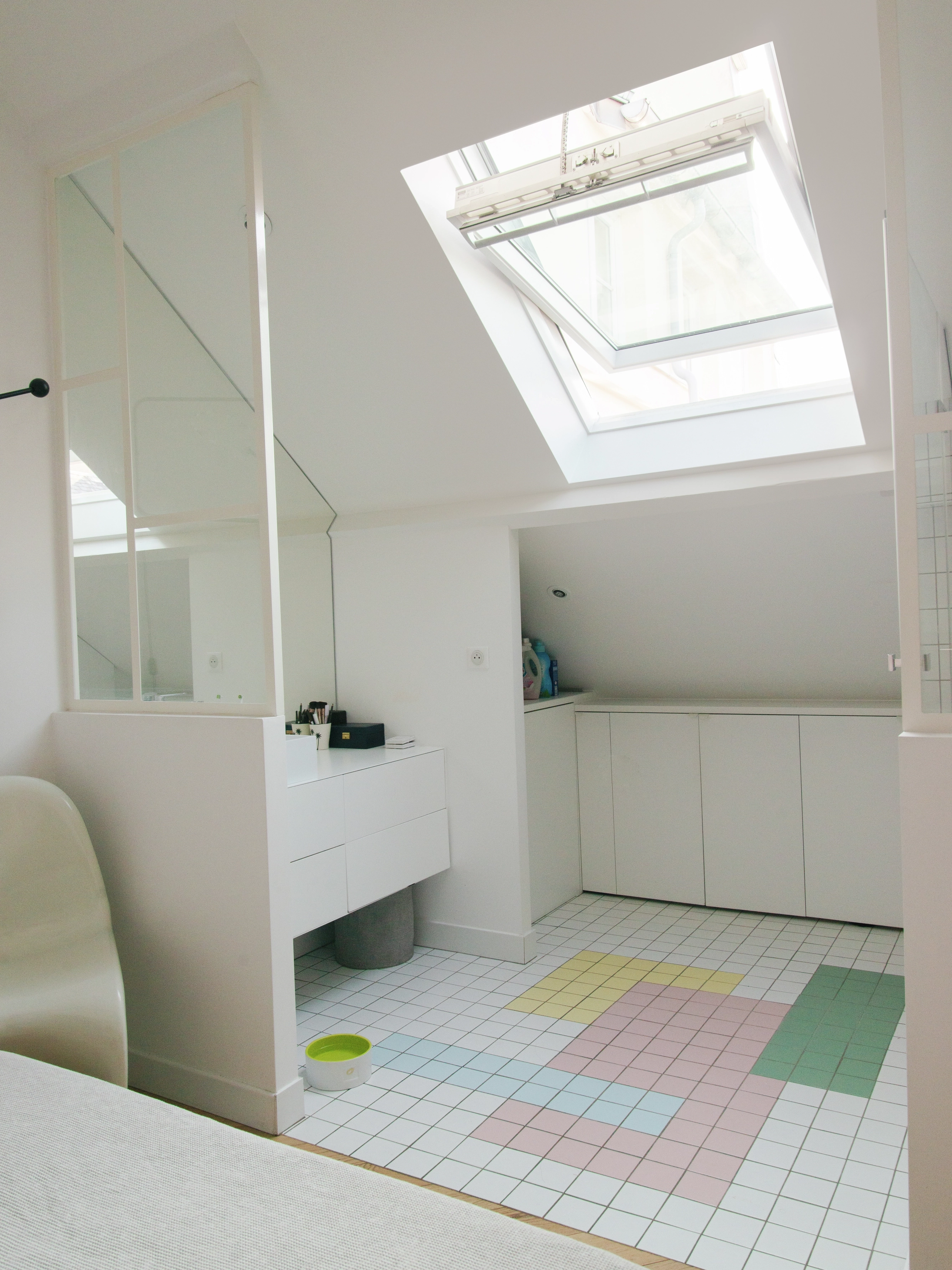 Une pièce mansardée lumineuse et aérée avec un tapis coloré, rendue intéressante par son utilisation efficace de l’espace et de la lumière naturelle grâce à la fenêtre de toit Velux.