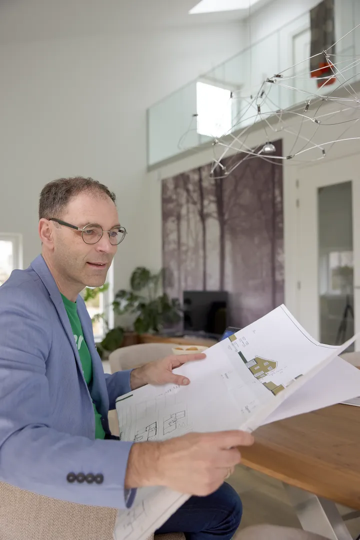 Muškarac pregleda građevinske planove u svijetloj sobi | VELUX