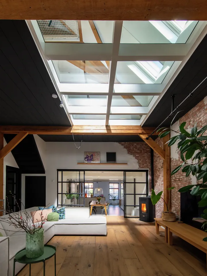 Zeitgemäßes Loft mit natürlichem Licht durch VELUX-Fenster, freiliegendem Mauerwerk und moderner Einrichtung.
