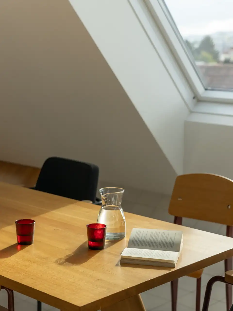 VELUX çatı pencerelerinden gelen gün ışığıyla aydınlanan masa.