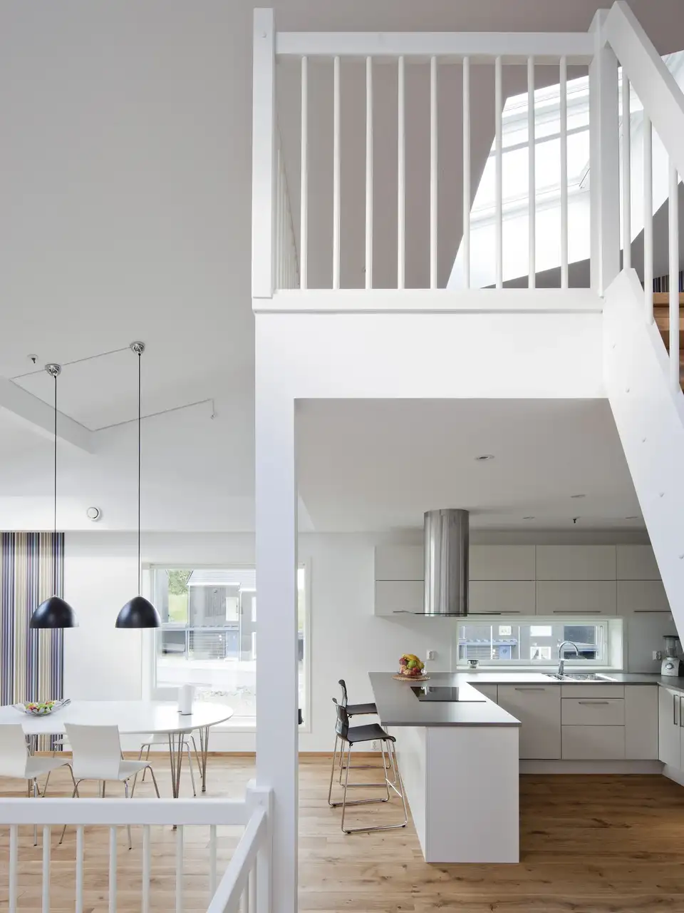 Cuisine et salle à manger en open space avec mezzanine et fenêtres de toit VELUX