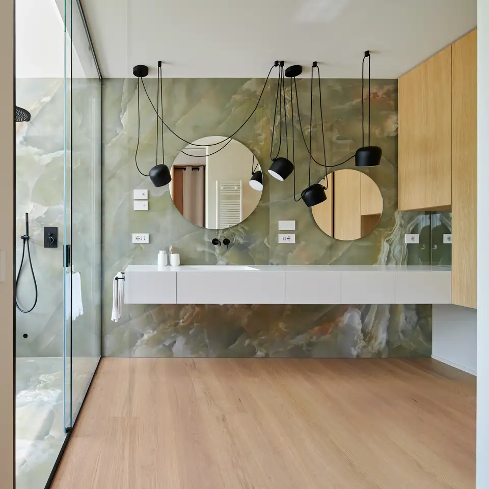 Cuarto de baño con ducha, suelos de madera y revestimientos de pared de mármol 