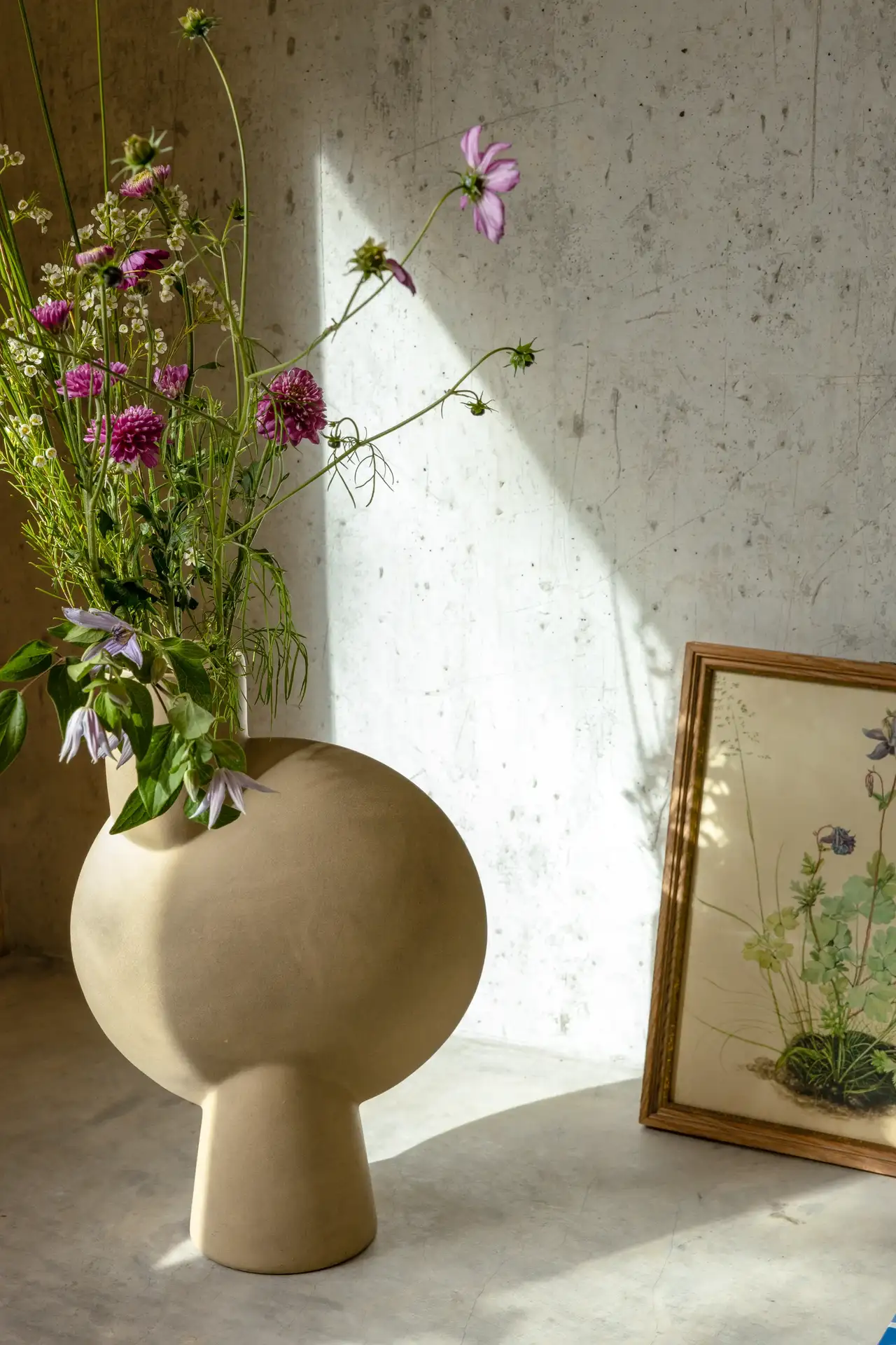 Minimalistische, kugelförmige Vase mit violetten Wildblumen | VELUX Magazin