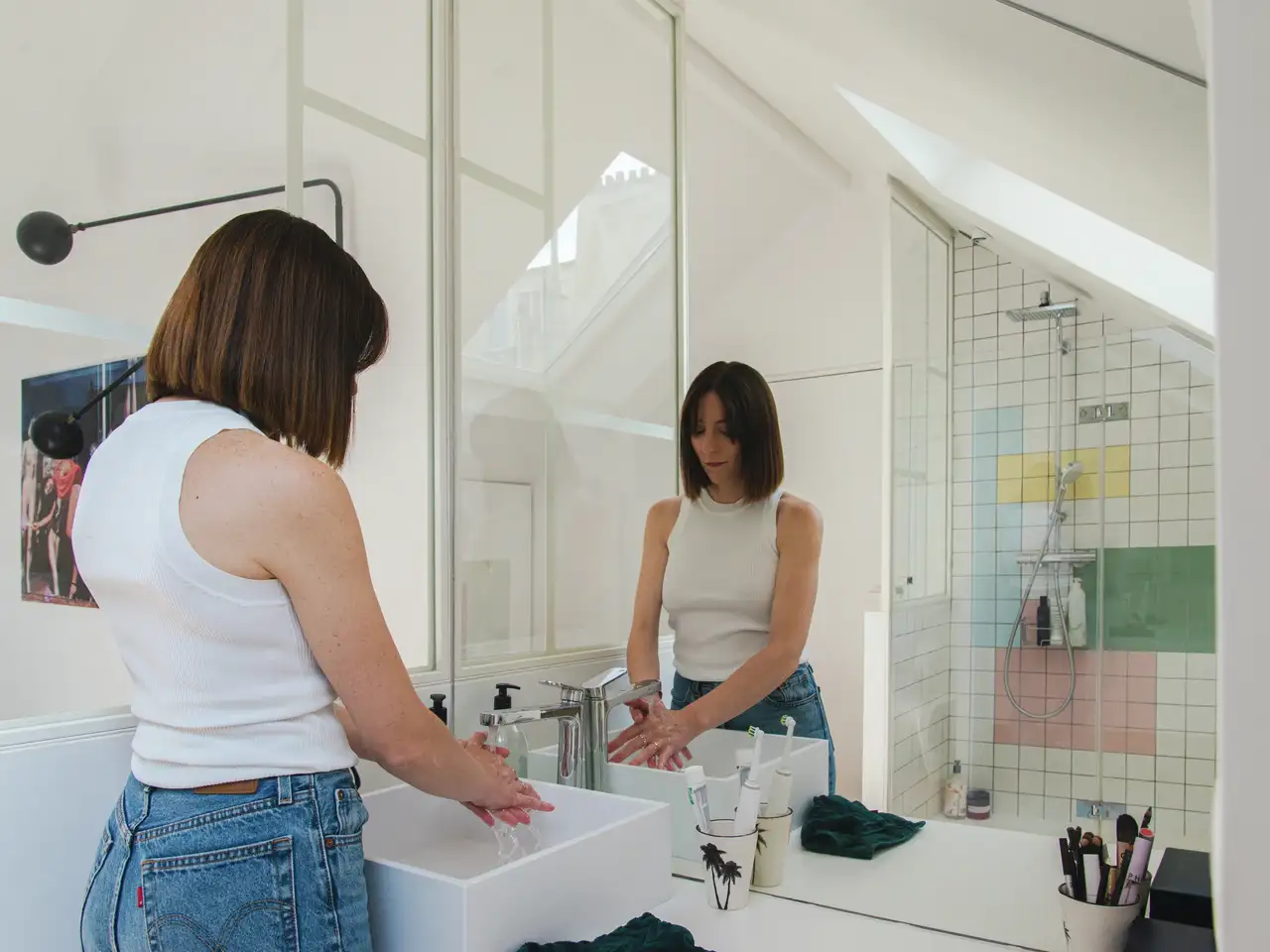 Donna che si lava le mani in un bagno con tetto spiovente | Rivista VELUX