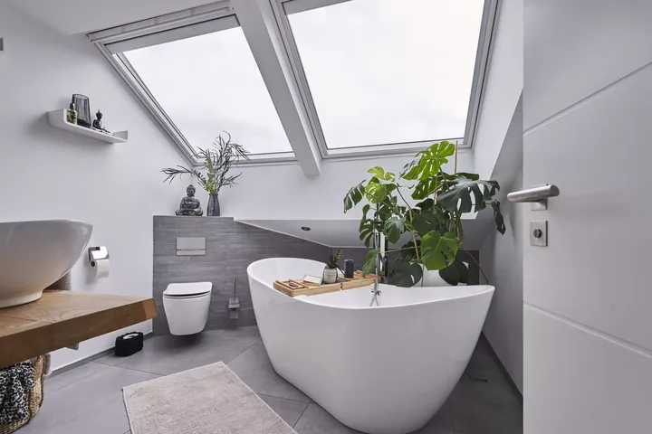 Modernes Badezimmer mit freistehender Badewanne und VELUX Dachflächenfenster, das für reichlich natürliches Licht sorgt.