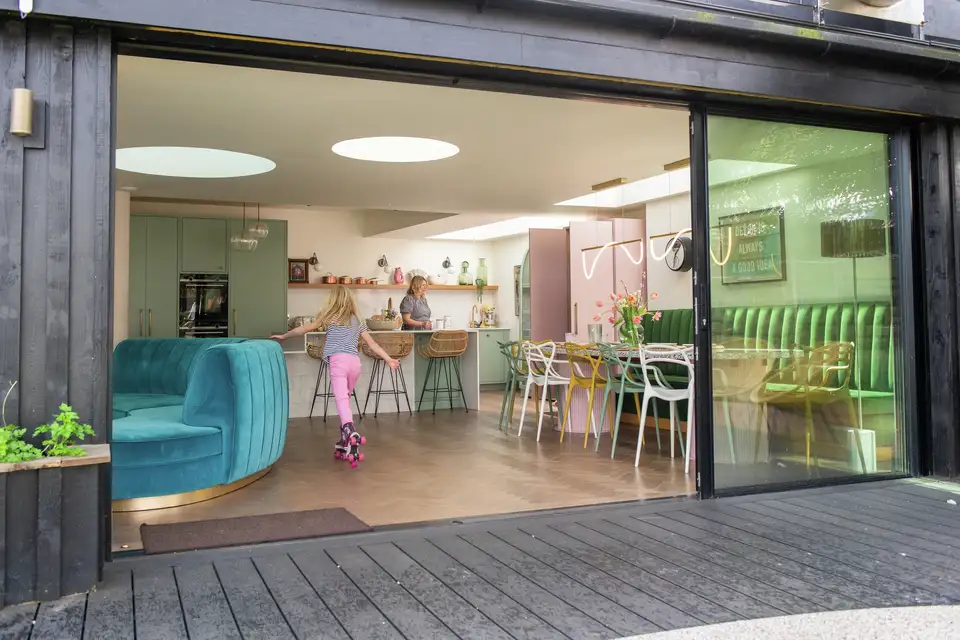 Modern kitchen with skylights, child roller skating inside. 