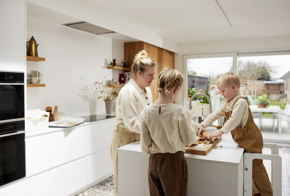 Light and airy kitchen decor: A family creates memories while baking together at the kitchen island