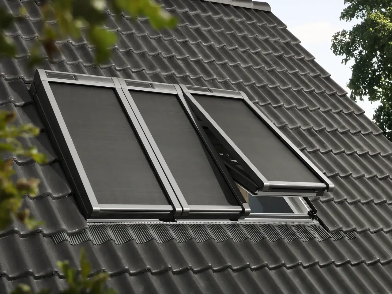 Vista esterna del tetto con tre lucernari VELUX e tende di protezione termica | Rivista VELUX