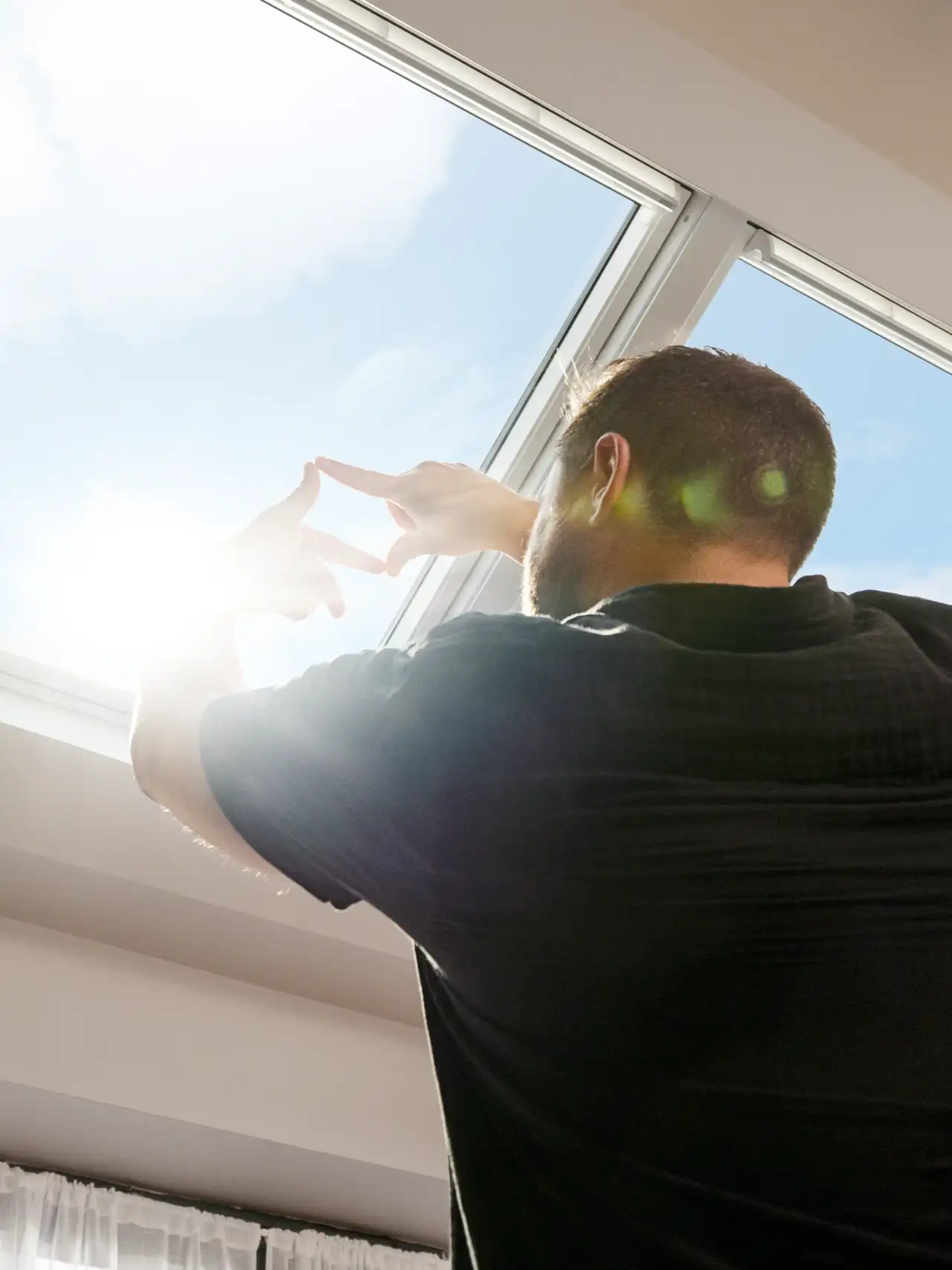 Couple activant le système de fenêtre intelligente VELUX Active depuis leur smartphone.