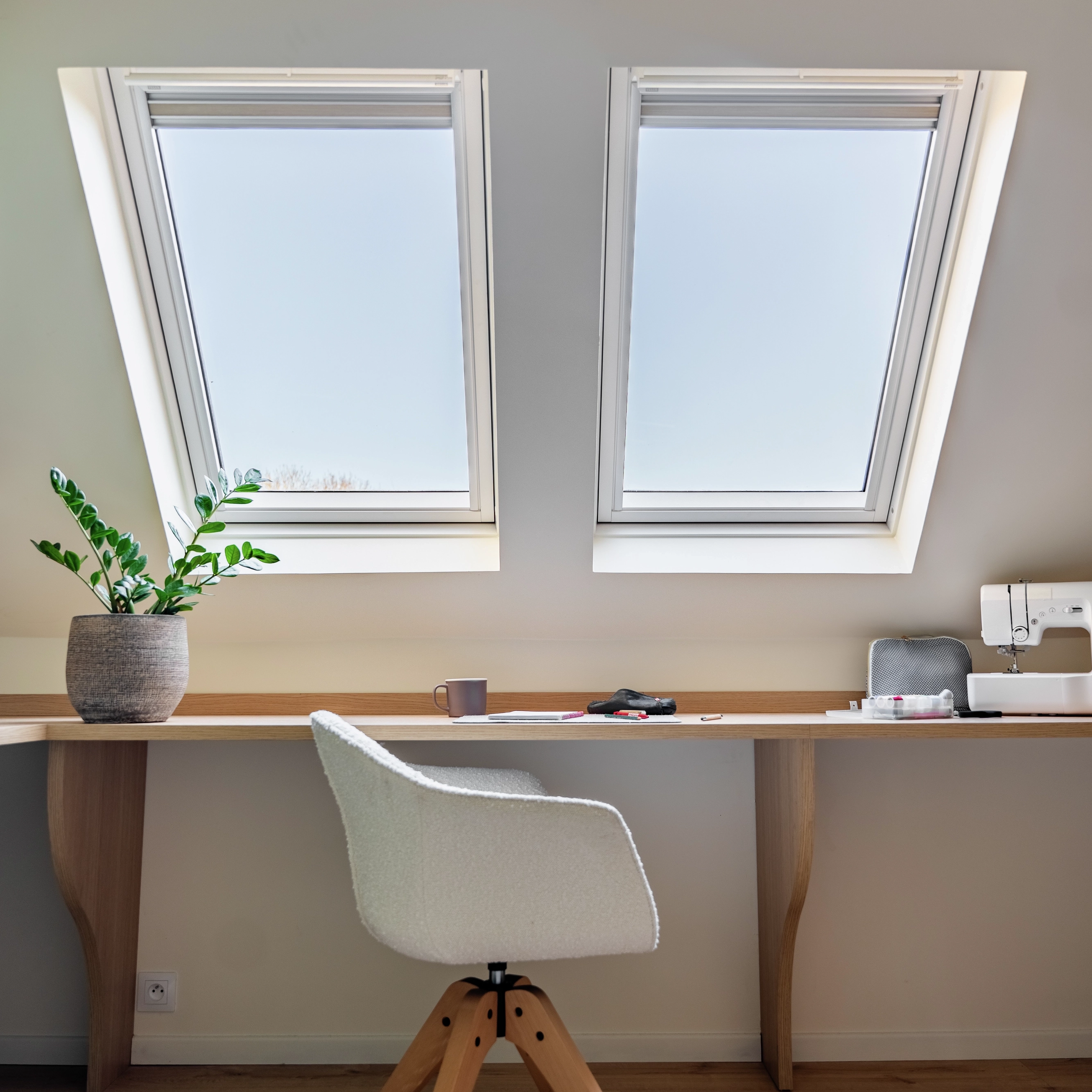 Chambre sous combles avec bureau sous fenêtre de toit
