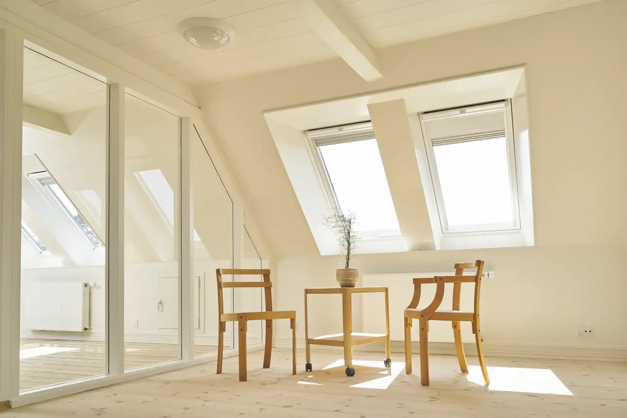 Minimalistische Esszimmermöbel aus Holz unter geöffneten Dachfenstern | VELUX Magazin
