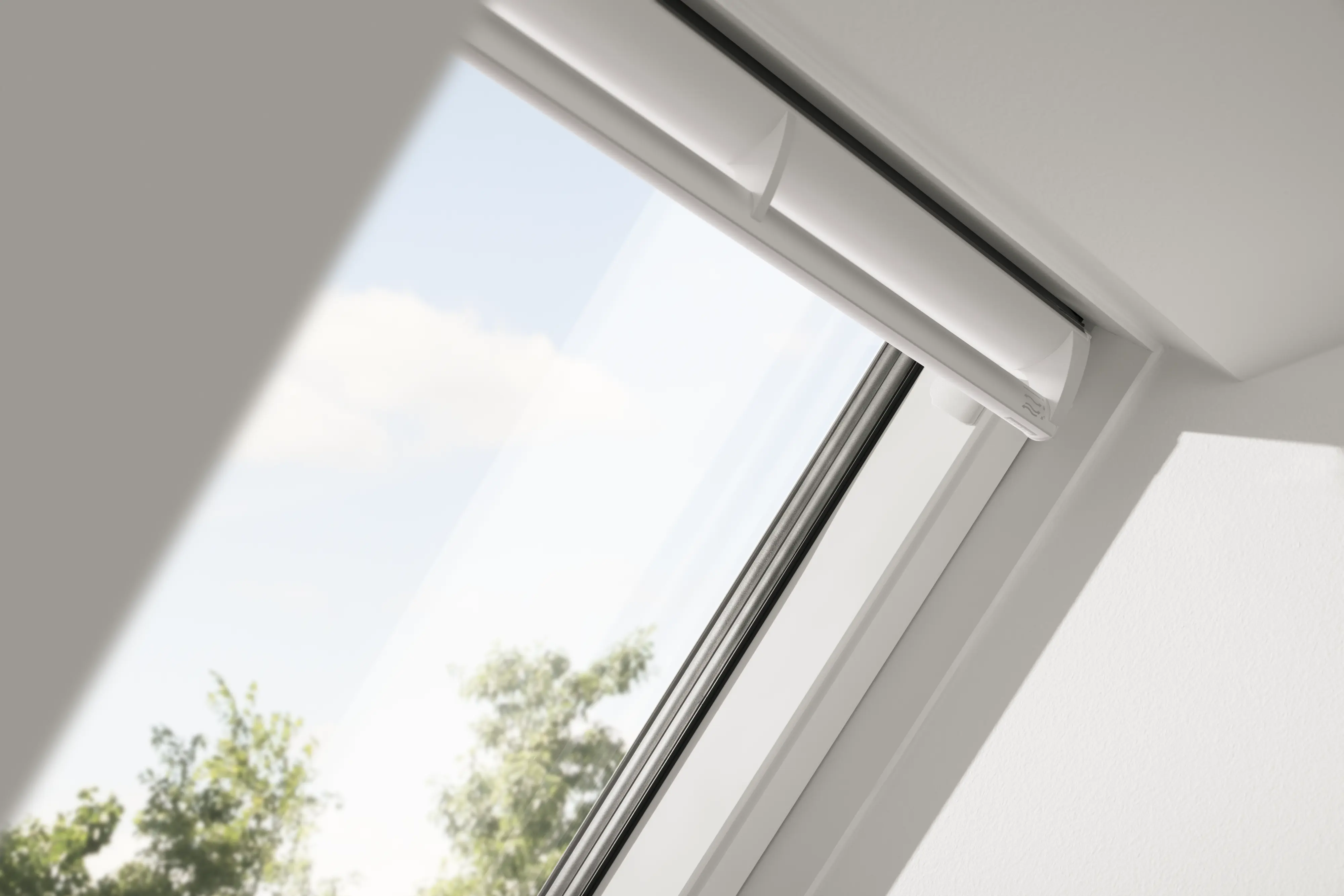 Fenêtre de toit VELUX ouverte avec vue sur le ciel et les nuages 