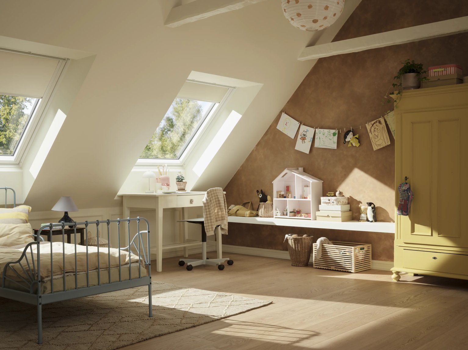 Attic kids room with sloped ceiling and VELUX roof windows and blinds, filled with natural light.
