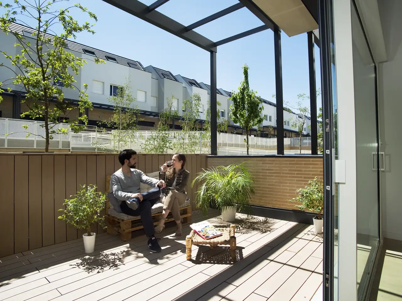 terrasse revêtue de lames, plantes, coin détente relié aux pièces intérieures 