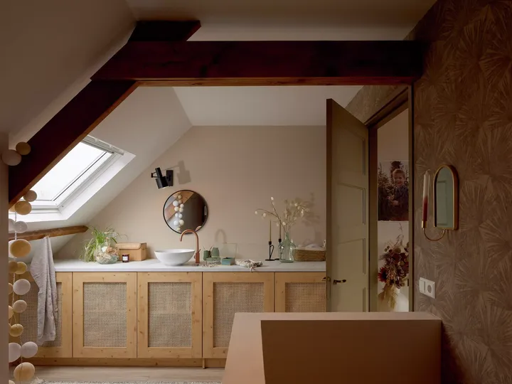 Badezimmer im Dachboden mit VELUX Dachflächenfenster, hölzernen Schränken und moderner Ausstattung.
