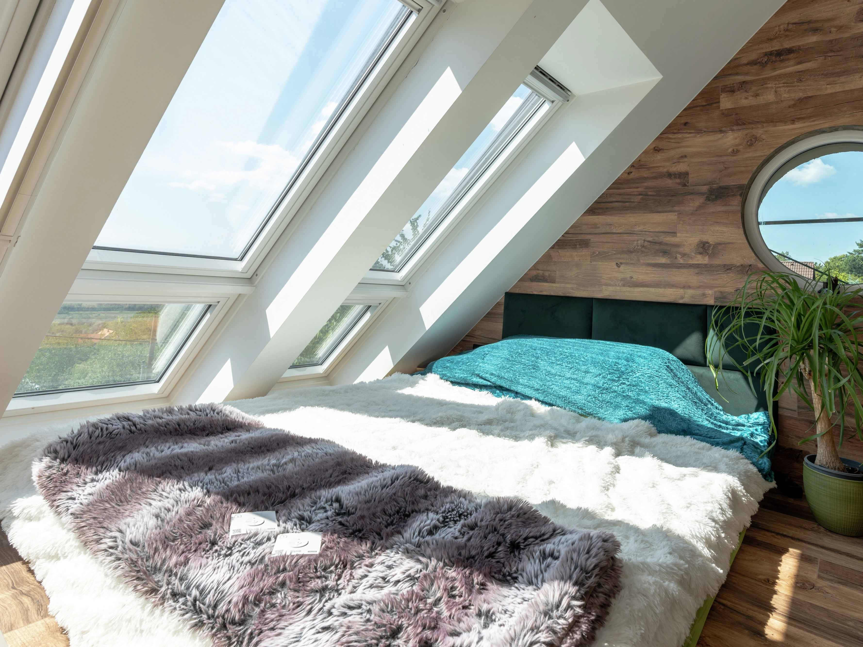 Attic bedroom with VELUX roof windows and cozy bed.