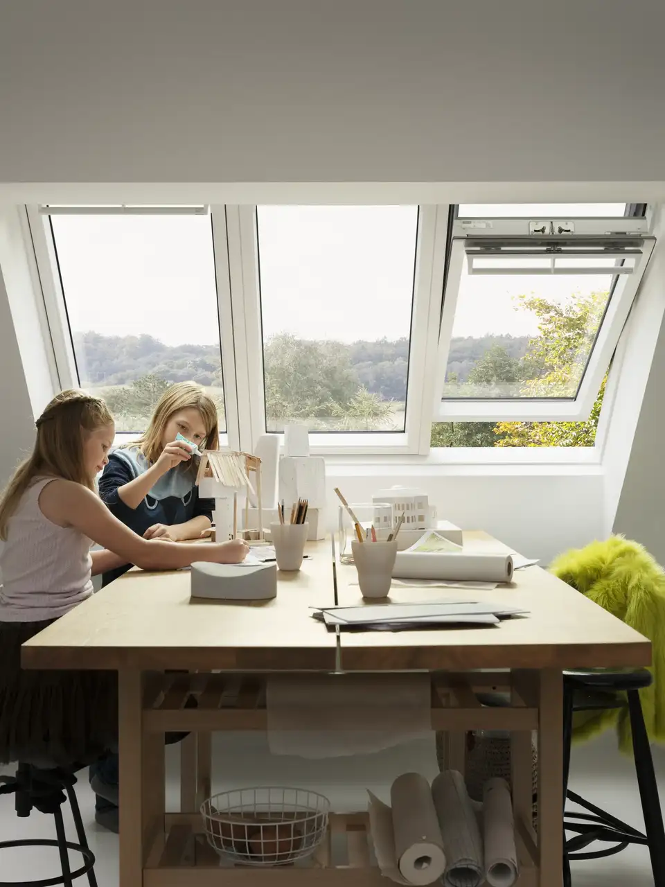 Salon mansardé baigné de lumière grâce à une verrière 3en1 VELUX composée de deux ouvrants et un fixe 