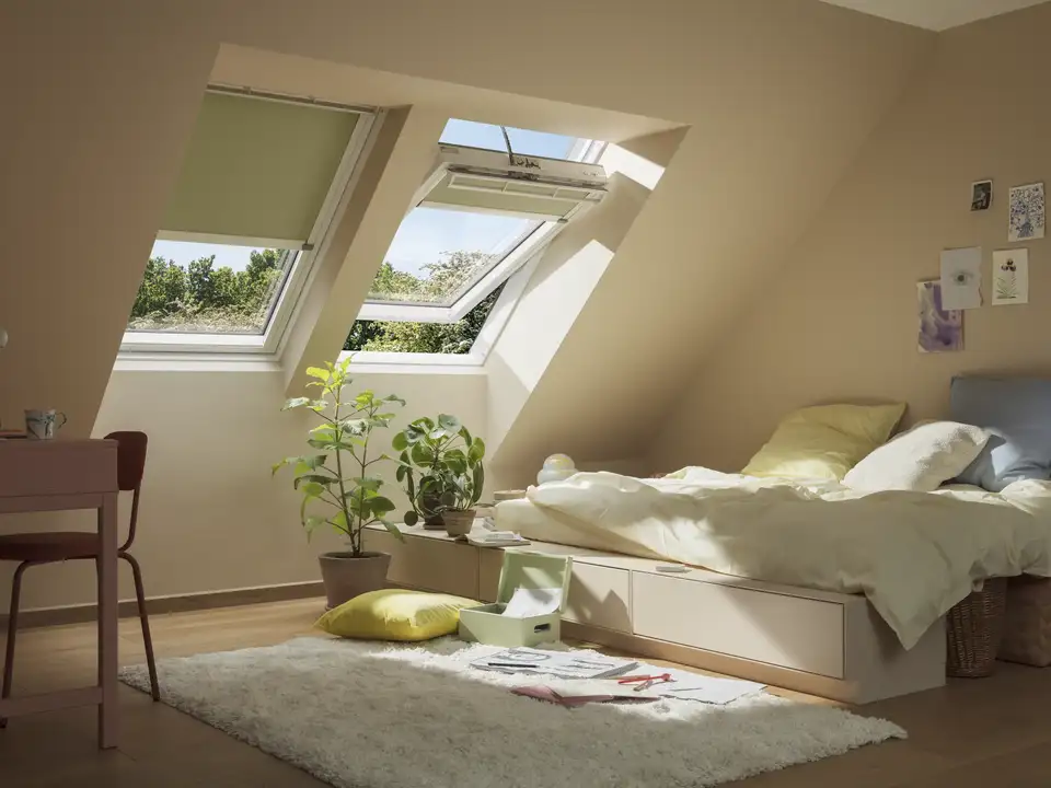 Camera da letto con due finestre per tetti VELUX affiancate e tende oscuranti.