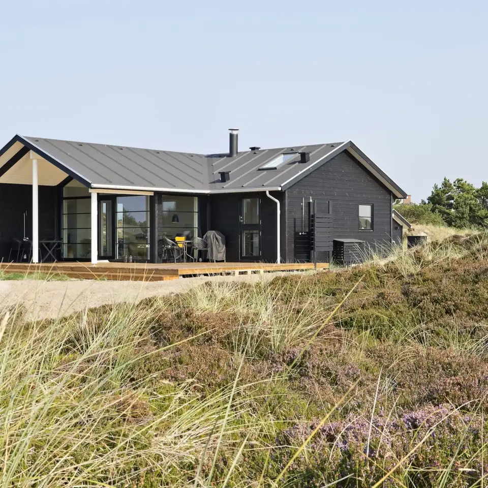 Indretning af sommerhus med naturlig belysning fra store vinduer, der sikrer lysindfald hele dagen